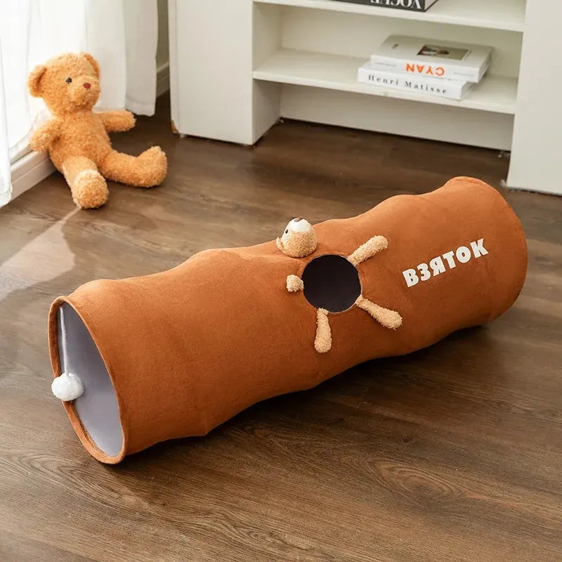Collapsible brown or grey cat tunnel with a plush ball on top, shown in both extended and folded flat positions.