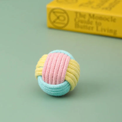 Handmade blue and pink cotton plush ball cat toy on a wooden floor