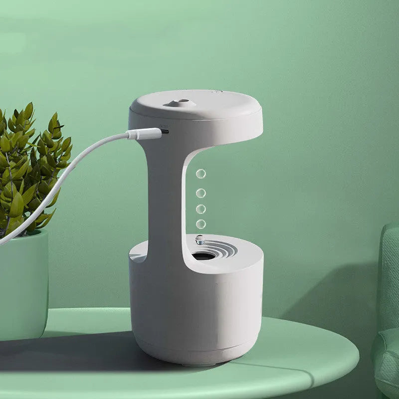 White columnar anti-gravity humidifier with LED clock display on a wooden desk