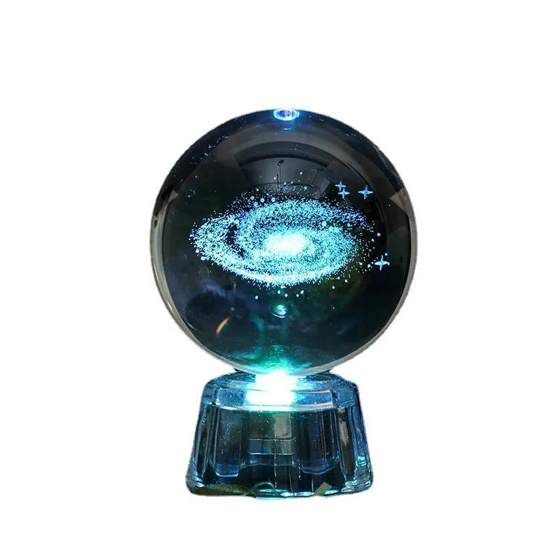 Transparent crystal ball ornament with inner carving of clouds, shown on a wooden table.
