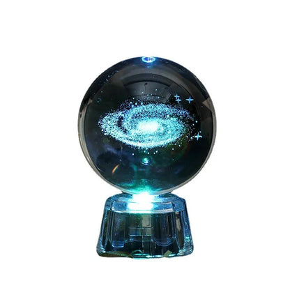 Transparent crystal ball ornament with inner carving of clouds, shown on a wooden table.