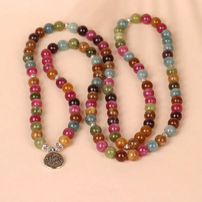 Close-up of a multi-layer beaded bracelet with 108 tourmaline beads and alloy string, showing lotus hanging detail.
