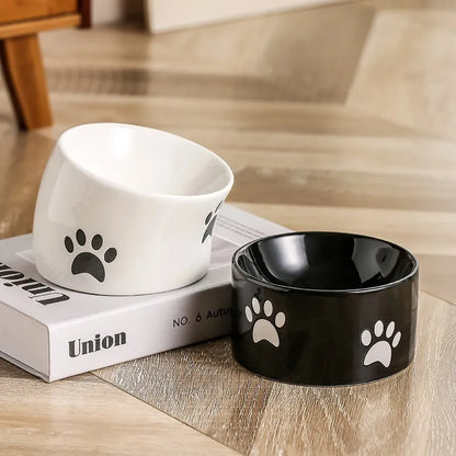 Ceramic cat bowl with high foot and cat's paw base in an oblique mouth design.