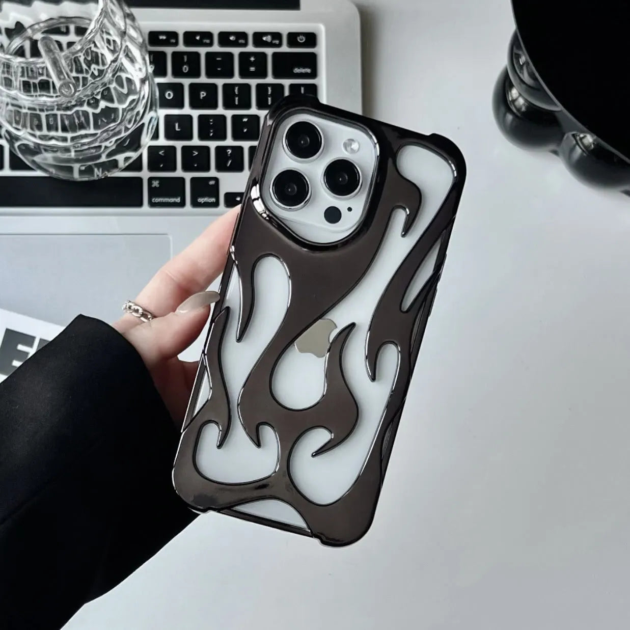 Electroplated hollow flame pattern phone case in silver plated finish on Apple iPhone, showing heat dissipation design and TPU soft shell