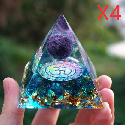 A small 6cm clear epoxy resin pyramid ornament containing pieces of natural crystal gravel on a flat surface.