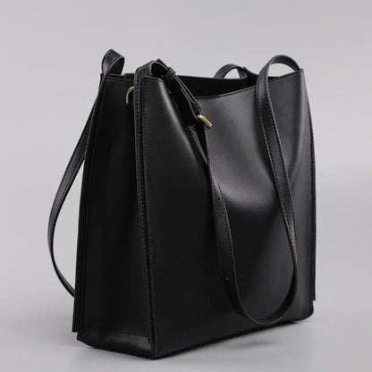 Brown genuine leather women's bucket bag with double shoulder straps showing organisational compartments