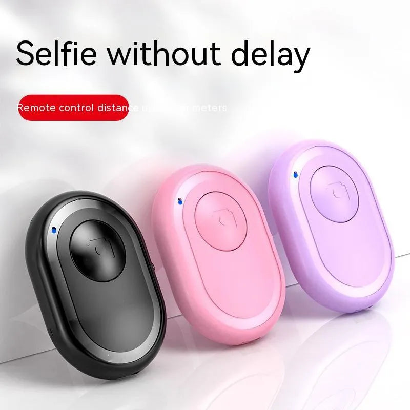 Small black wireless Bluetooth remote control for smartphone camera with self-timer function.