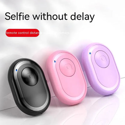 Small black wireless Bluetooth remote control for smartphone camera with self-timer function.