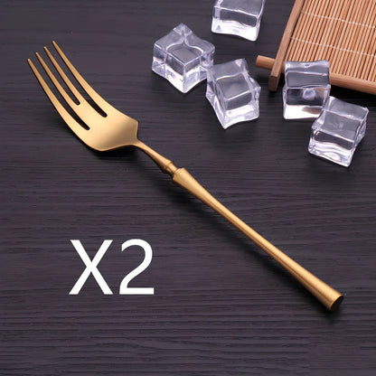 Four-piece stainless steel cutlery set showing main knife, fork, spoon, and teaspoon with mirror finish