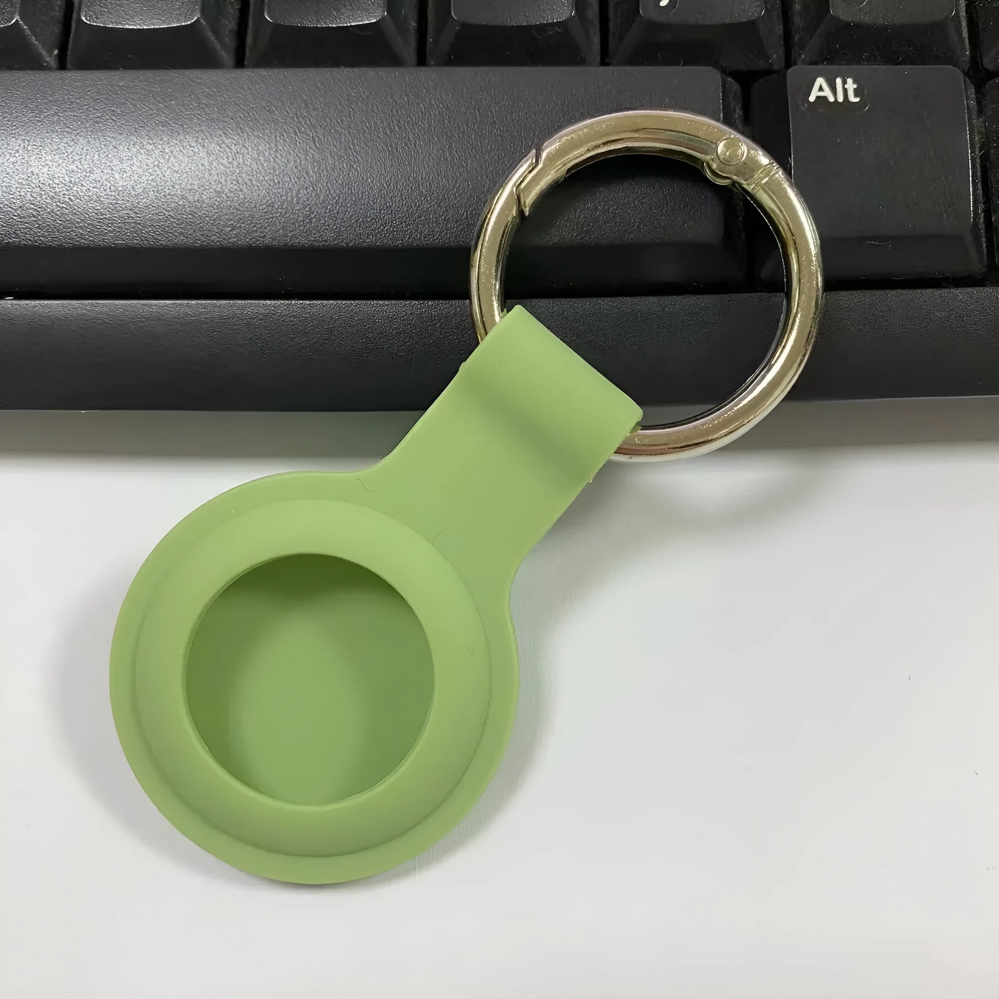 Black waterproof silicone Airtag protective case with metal keychain clip, shown next to colour options.