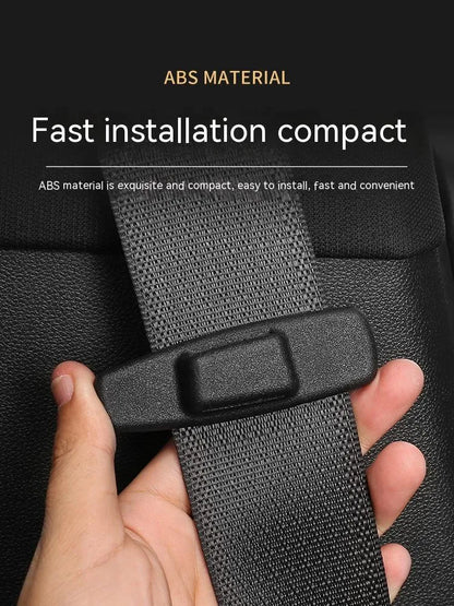 Two black ABS plastic car seat belt stopper clips on a clear OPP bag.