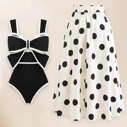 Women's black one-piece swimsuit with white skirt and bow detail for beach swimming