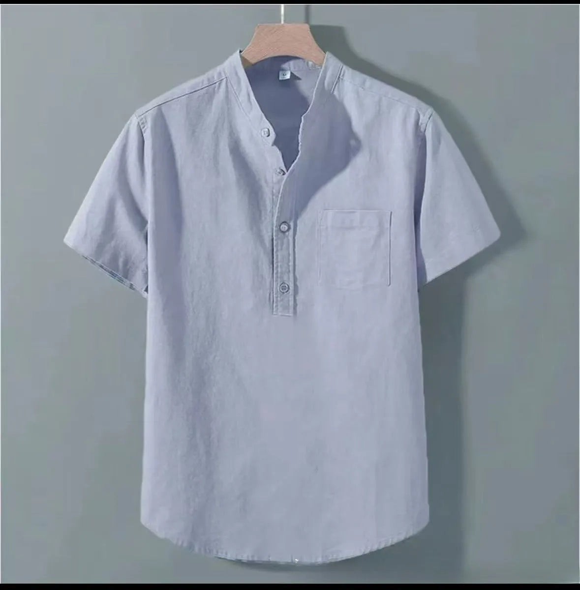 Man wearing a beige loose-fit linen blend casual shirt with a stand collar and short sleeves.