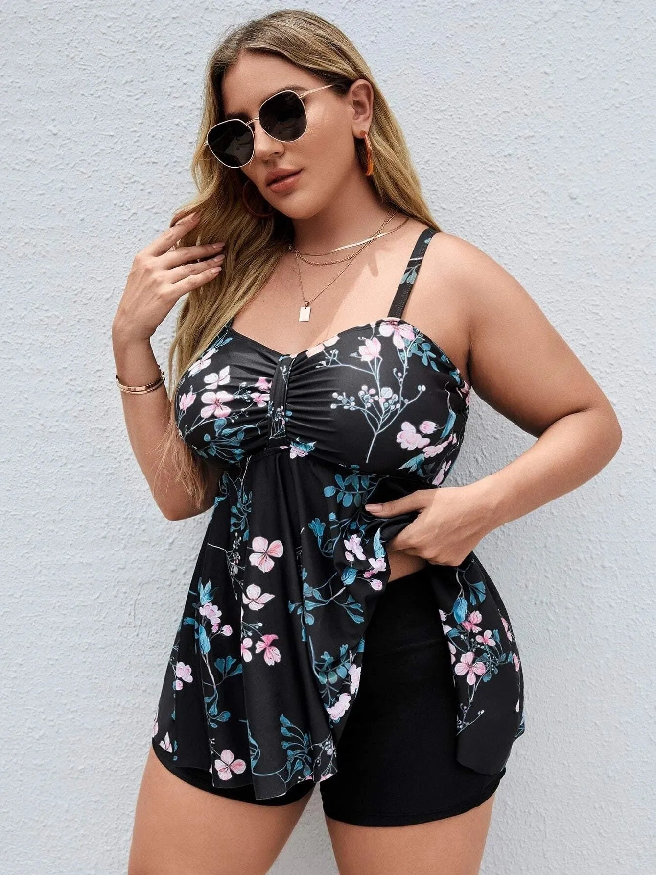 Women's one-piece swimsuit with a split colour floral print, shown on a mannequin.