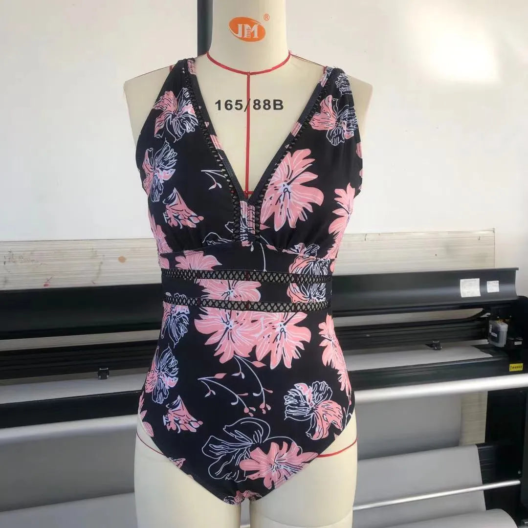 Black plus-size bikini swimsuit with print design and mesh fabric, shown on a hanger.