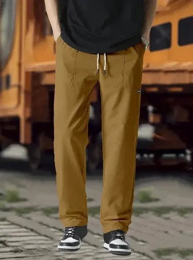 Men's polyester trousers for spring and autumn in light grey, shown in a casual setting