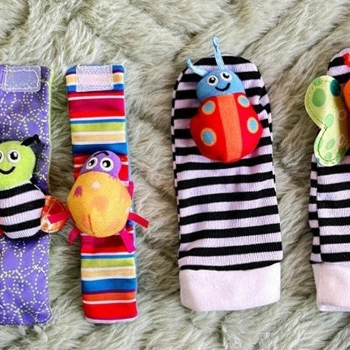 Four fabric baby socks with cartoon designs and ringing feature for infant training