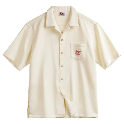 Light apricot men's shirt with a bamboo plant pattern and a Cuban collar laid flat.