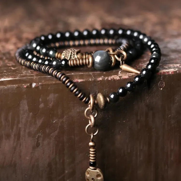 Black geometric layered beaded bracelet shown on a wrist.