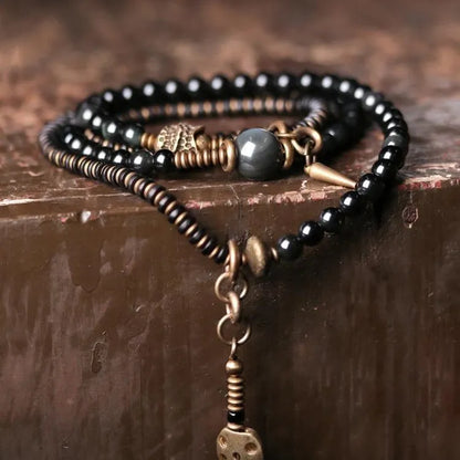 Black geometric layered beaded bracelet shown on a wrist.