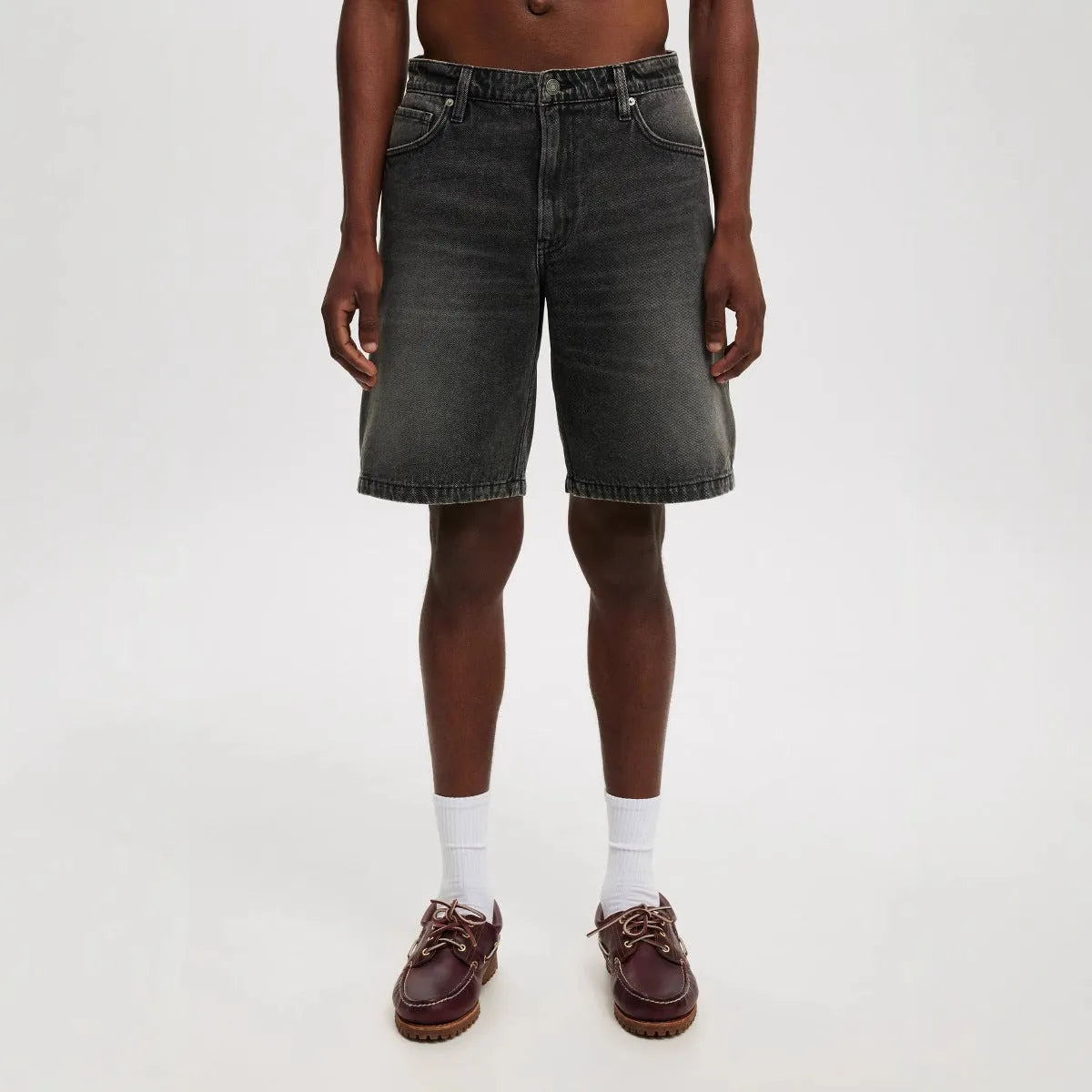Men's light blue loose-fit straight-leg cotton jeans on a neutral background.