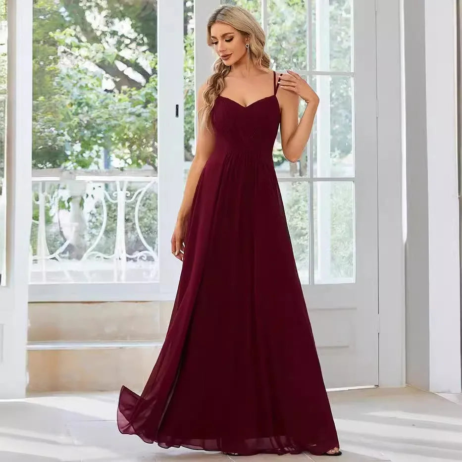 Women's sleeveless long dress with sling neckline and pleated A-line skirt in a solid colour.