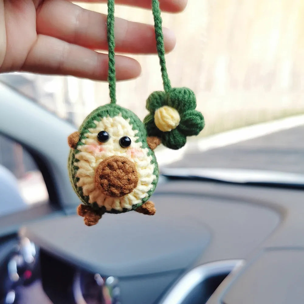 Handmade crocheted cartoon-style car pendant in wool, shown in avocado, pink rainbow, and red rainbow colour options.