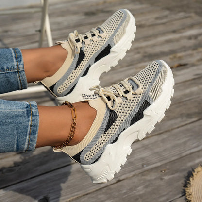 Women's Flyknit mesh lace-up sneakers in a grey colourway on a white background