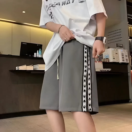 Man wearing loose-fit black baggy track pants with an elasticated waist for casual athletic wear