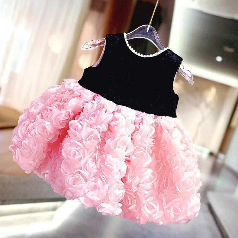 Pink girls summer dress with colour-matched design on hanger, showing polyester fabric texture