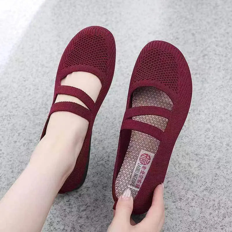 A pair of slip-on flat shoes with an elastic upper and rubber sole, shown in an embroidered colour option.