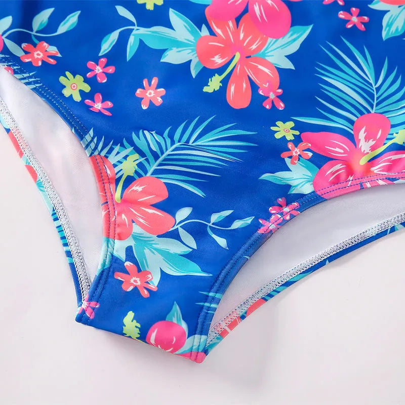 Girl's long-sleeve one-piece swimming suit in a briefs style on a hanger.