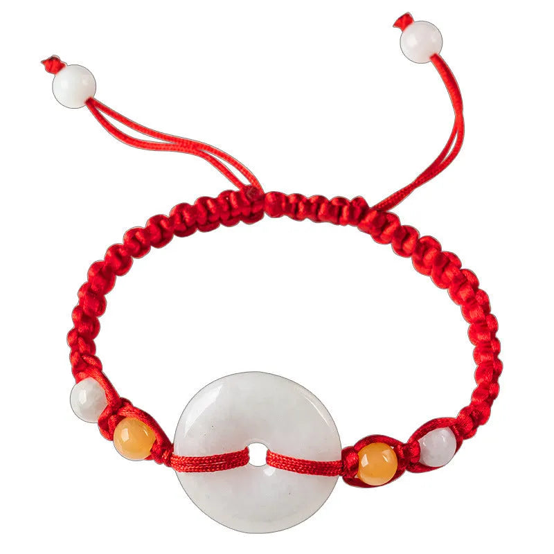 Round emerald green jade pendant on an adjustable red rope bracelet cord.