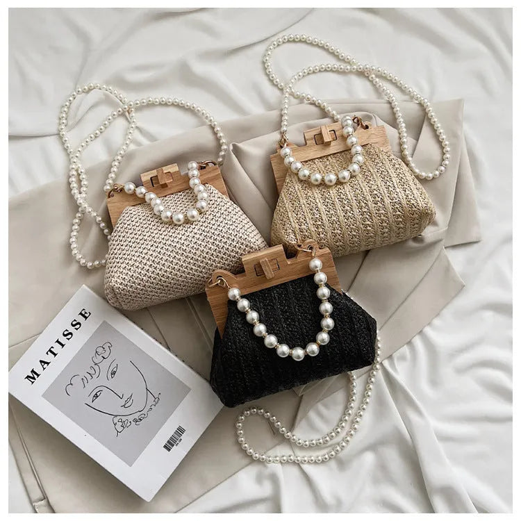 Women's beige straw woven shoulder bag with pearl chain strap, showing horizontal square shape and sewing line detail.