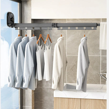 Aluminum retractable drying rack mounted on a window, extending outward for clothes drying