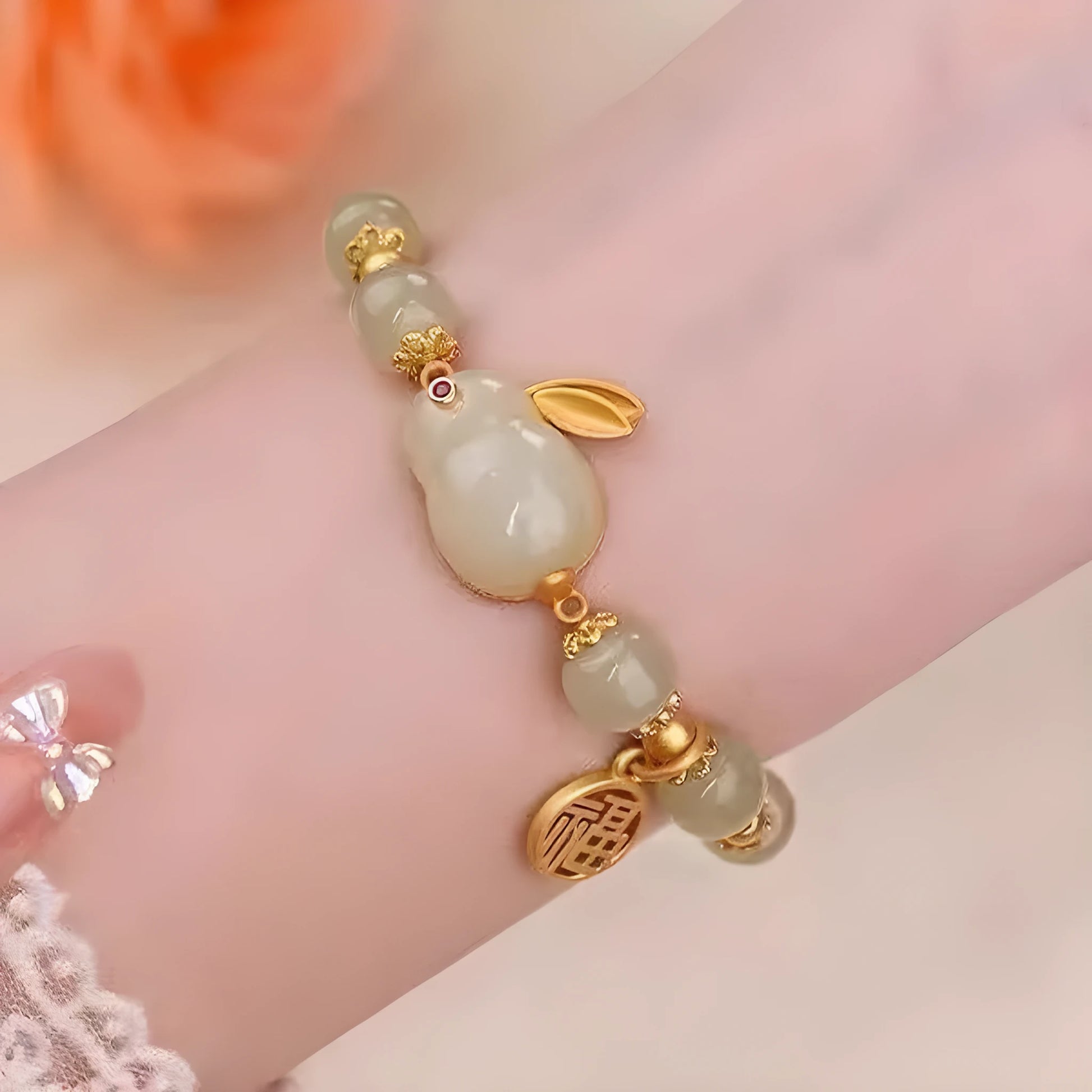 Green jade hare charm fu character bracelet with lily detail on black adjustable cord.