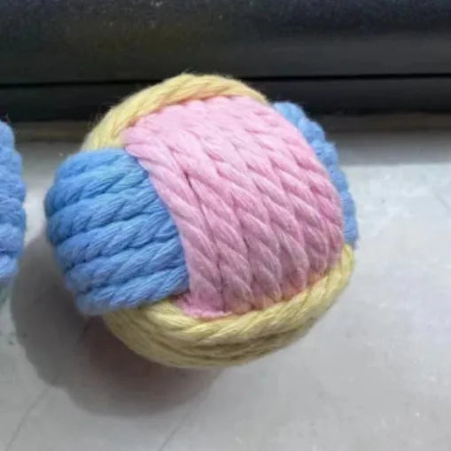 Handmade blue and pink cotton plush ball cat toy, 5cm in diameter, on a wooden floor.