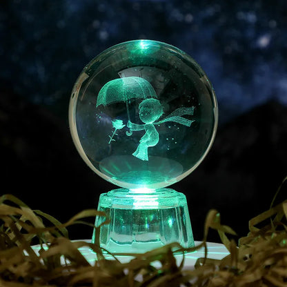 Transparent crystal ball ornament with inner carving of clouds, shown on a wooden table.