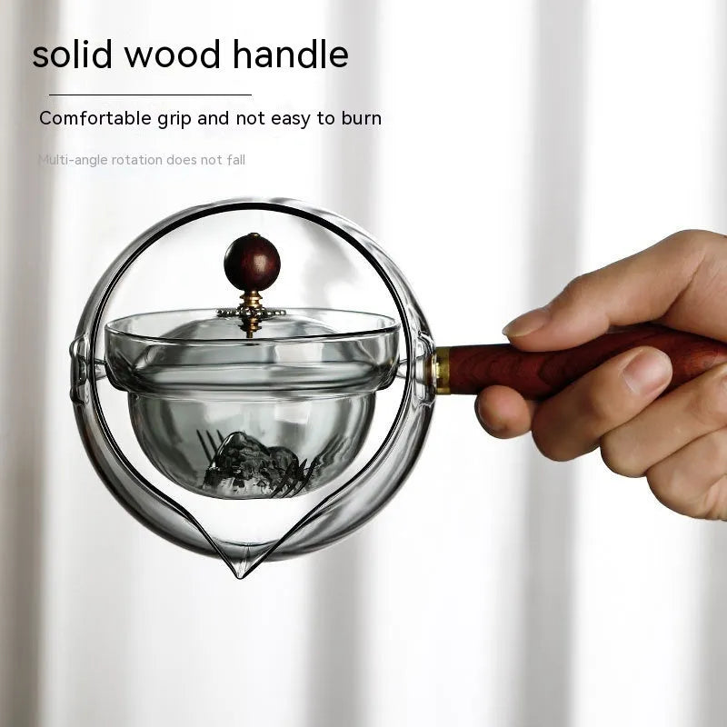 Glass teapot with wooden handle showing transparent borosilicate construction and removable infuser