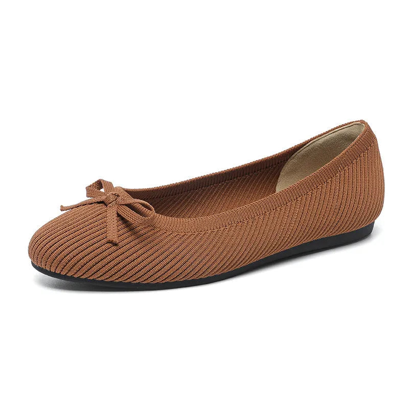 Women's black fabric flat pumps with a bow detail on the round toe, shown on a white background.