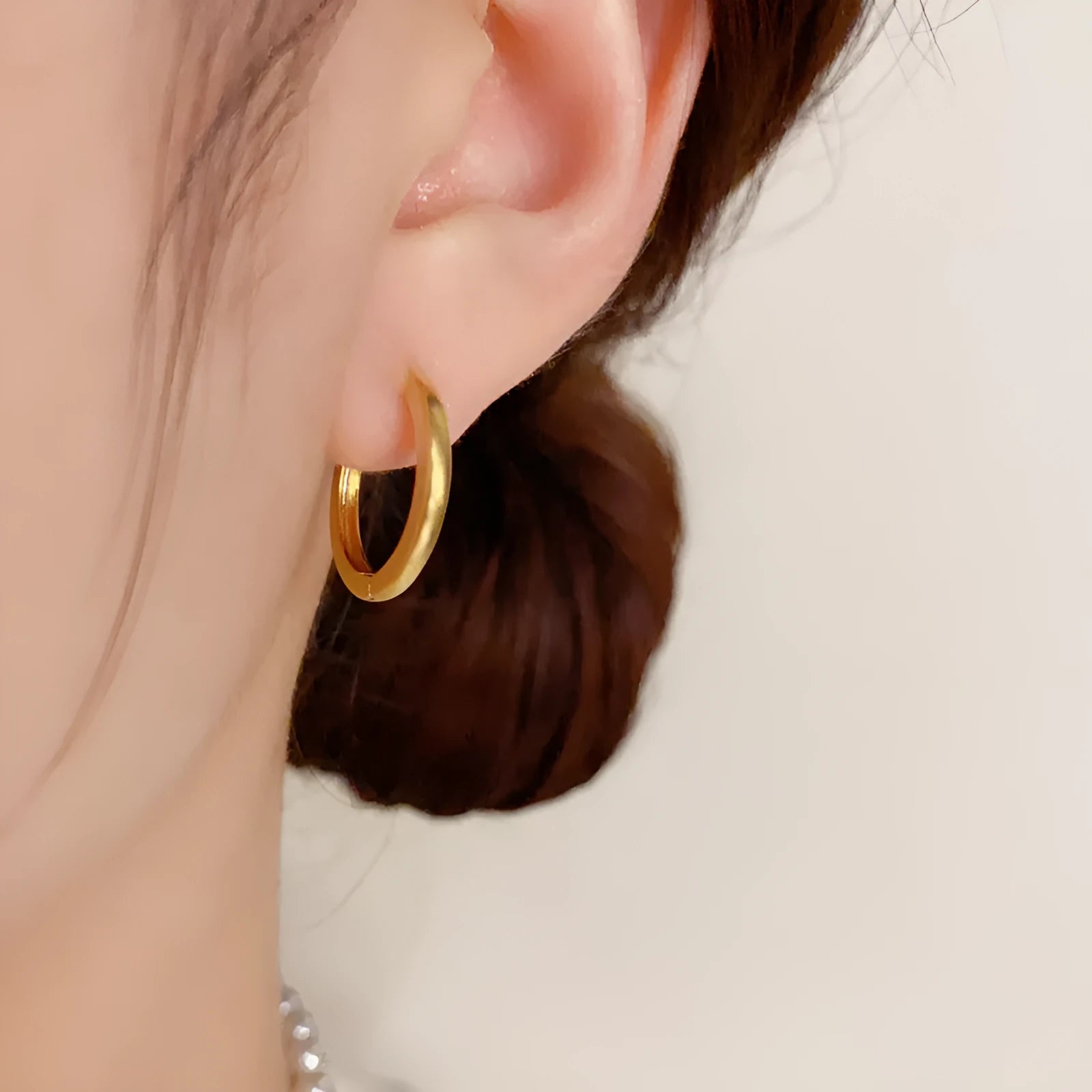 Geometric women's ear clip with round eyelet design in gold or silver colour