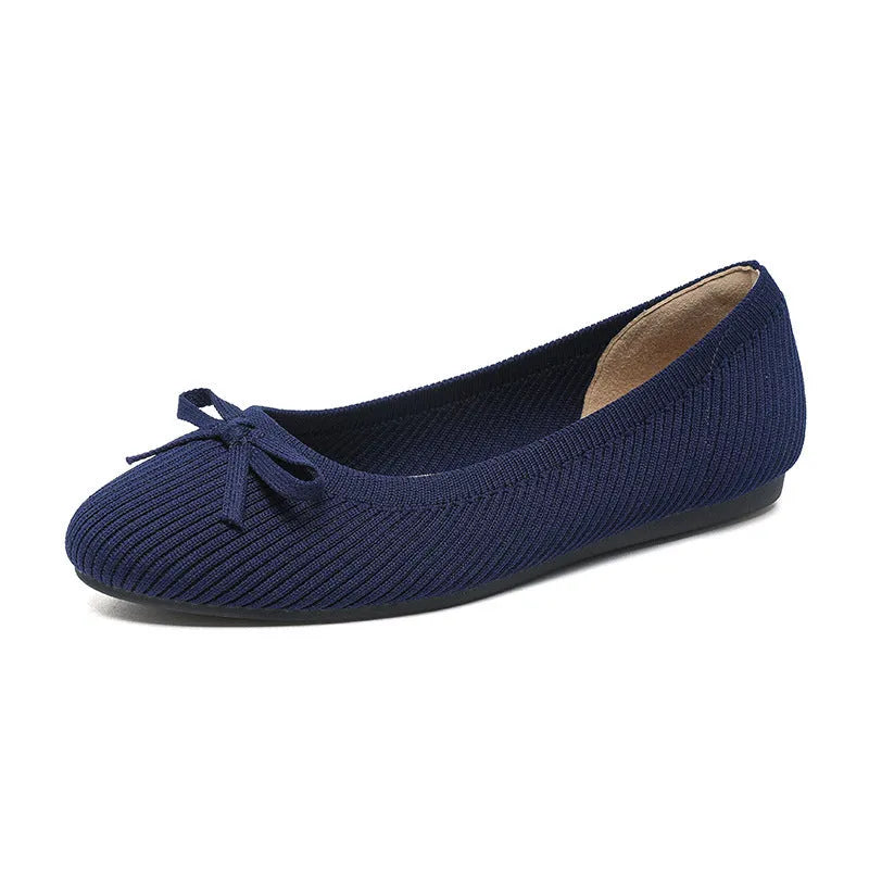 Women's black fabric flat pumps with a bow detail on the round toe, shown on a white background.