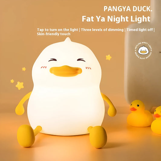 Chubby Night Light with soft glow on bedside table, holding a mobile phone in its silicone cradle.