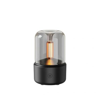 Compact black aroma diffuser humidifier with remote control on wooden surface