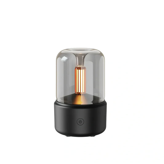 Compact black aroma diffuser humidifier with remote control on wooden surface