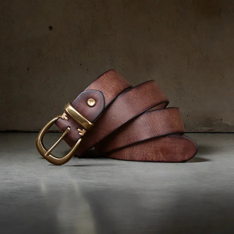 Men's black genuine cattlehide leather belt with a copper pin buckle on a jeans background.