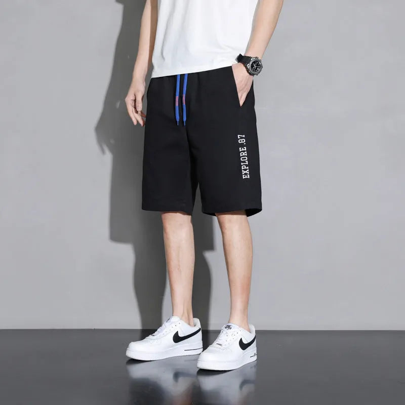 Cotton shorts for teenage boys in black, shown on a hanger, featuring a mid-waist design.
