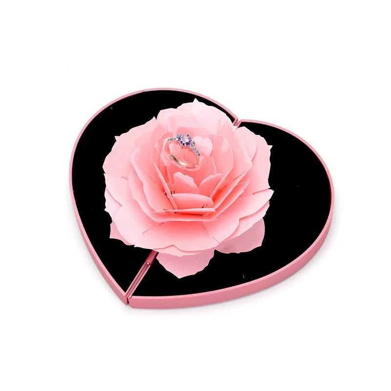 Red 3D heart-shaped plastic ring box with rose decoration on a rotating stand