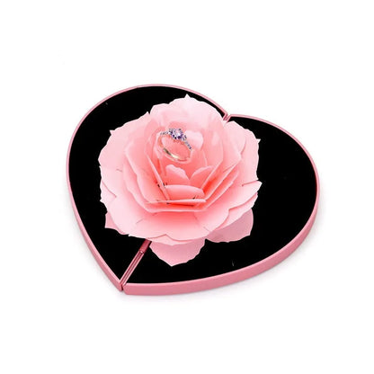 Red 3D heart-shaped plastic ring box with rose decoration on a rotating stand