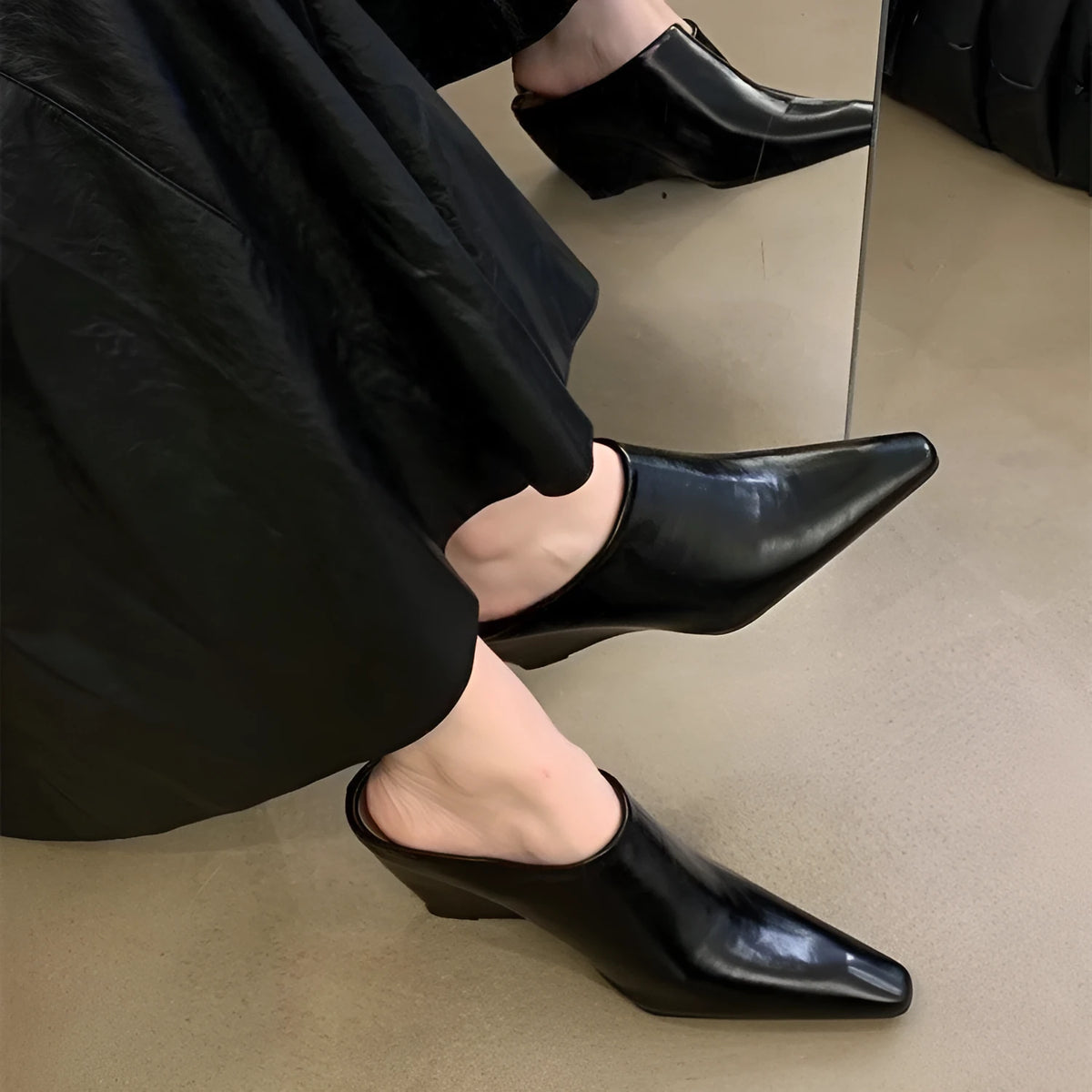 Women's black wind wedge closed toe half slippers on a plain background.